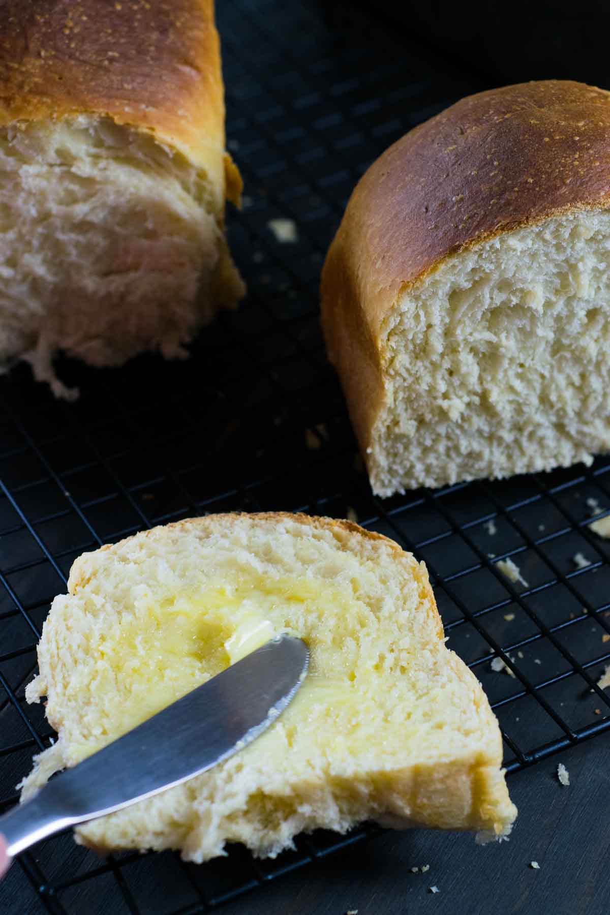 Imagem mostrando manteiga sendo espalhada em uma fatia de pão caseiro